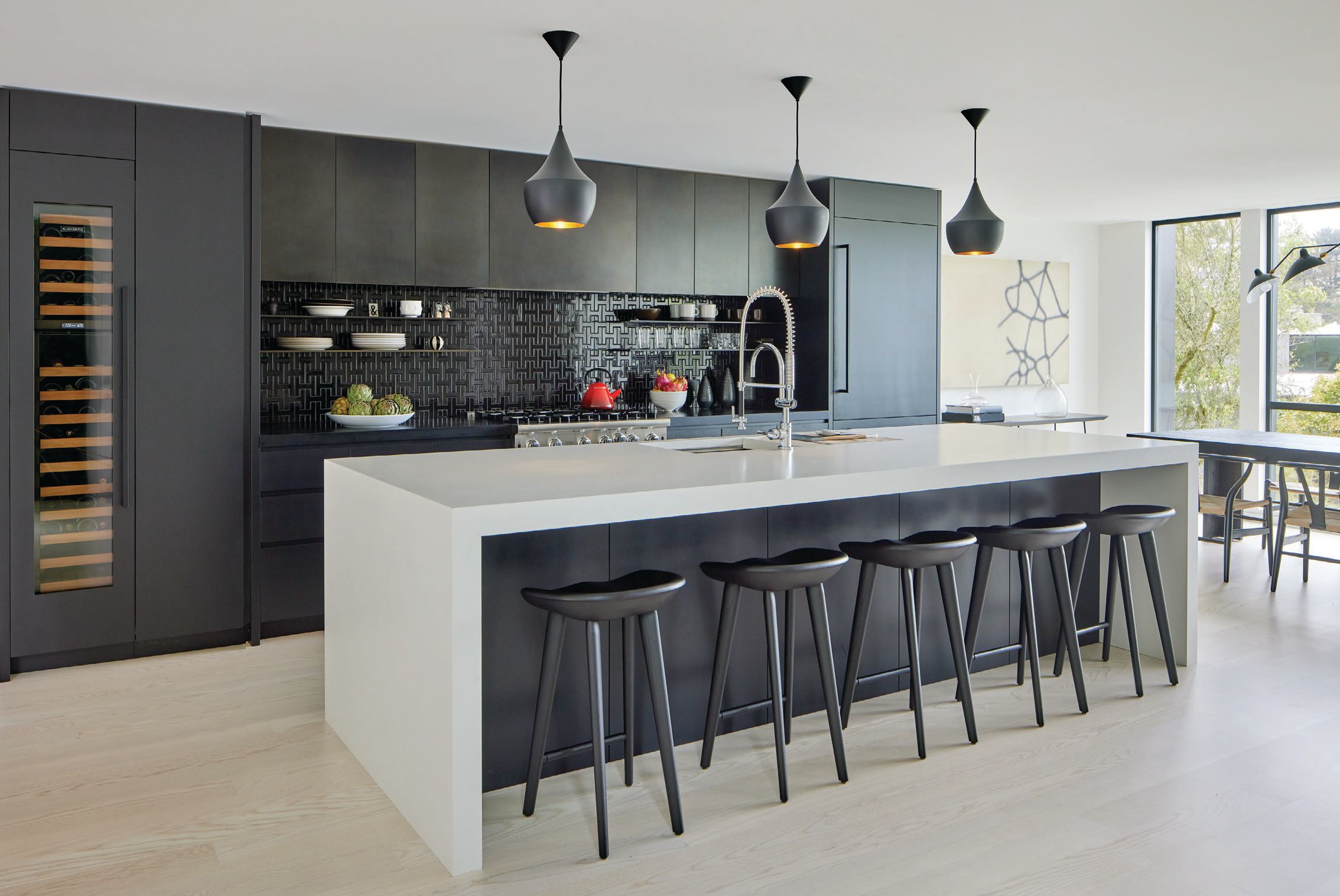 A Cambria countertop and tractor stools from DWR stand out in the black-and- white kitchen PHOTOGRAPHED BY BRUCE DAMONTE