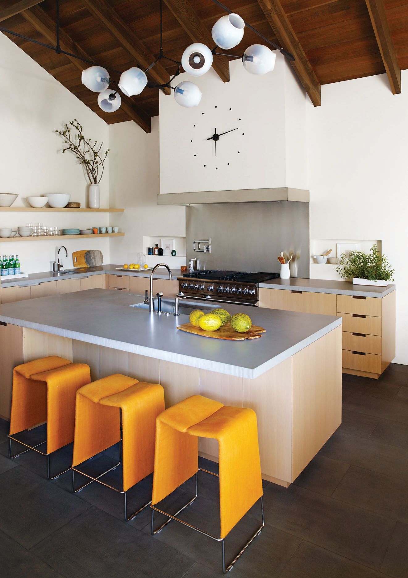 Lazy ’05 counter stools by B&B Italia in Christopher Hyland marigold fabric pair perfectly with the Lindsey Adelman Branching Bubble chandelier in the kitchen. PHOTOGRAPHED BY JAMES CARRIERE